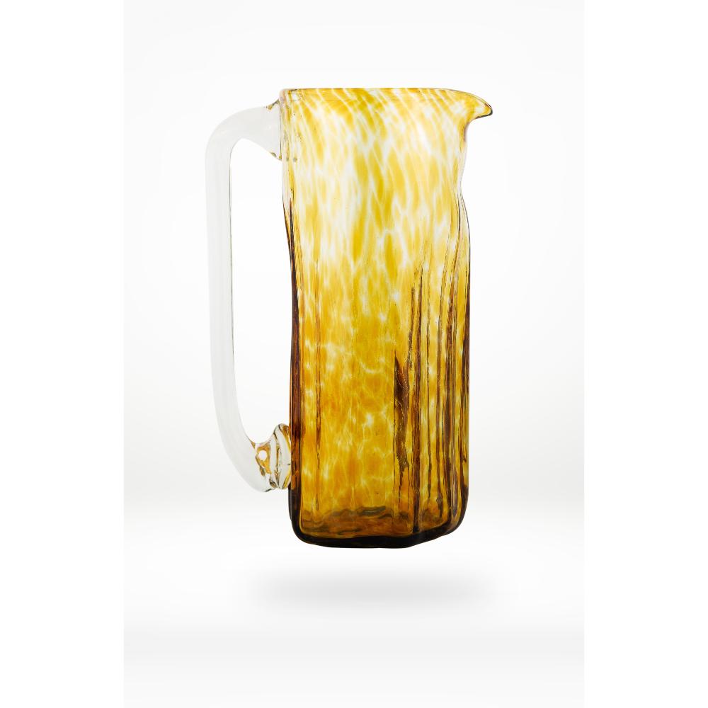 Glass pitcher with a yellow and brown pattern on a white background