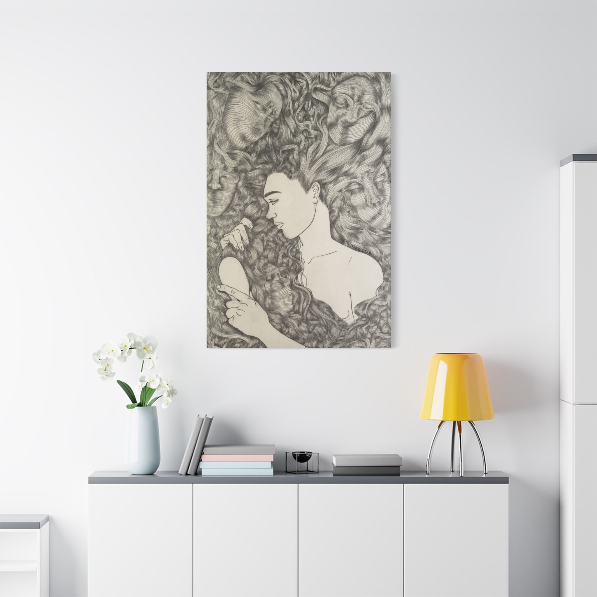 Abstract artwork of a woman with flowing hair on a white wall above a white cabinet.