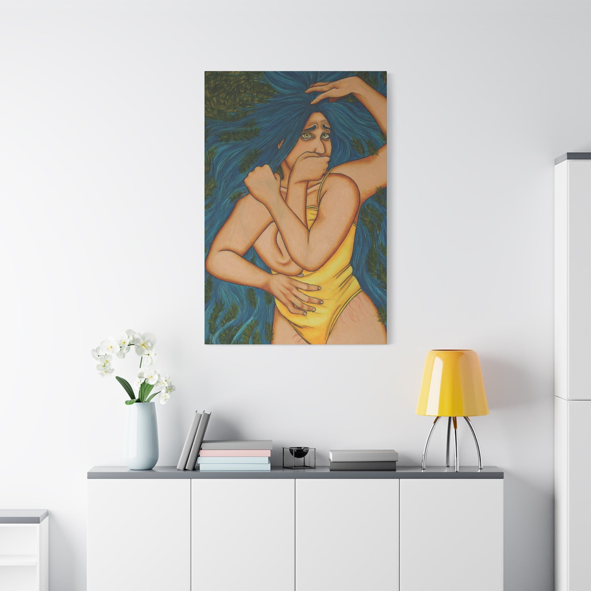 Artistic depiction of a woman with long blue hair in a yellow swimsuit on a white wall above a white cabinet.
