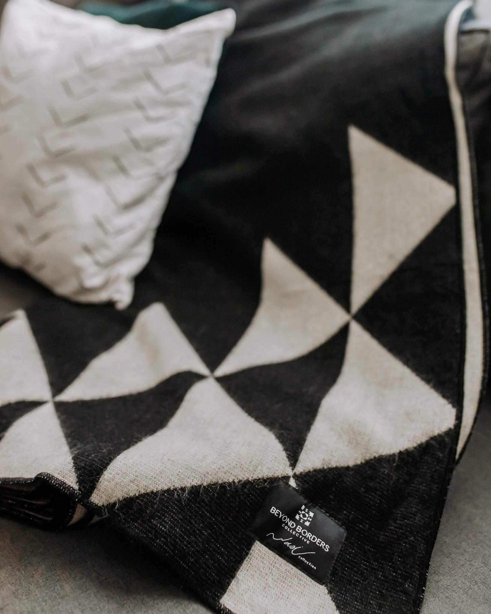 Nevado Blanket - Natural / Black | Named after the snow-capped volcanoes of the Ecuadorian Andes, the Nevado Blanket is part of our Wasi Monochrome Collection, inspired by the mystery and majesty of Ecuador’s landscapes. Its minimalist, monochromatic desi