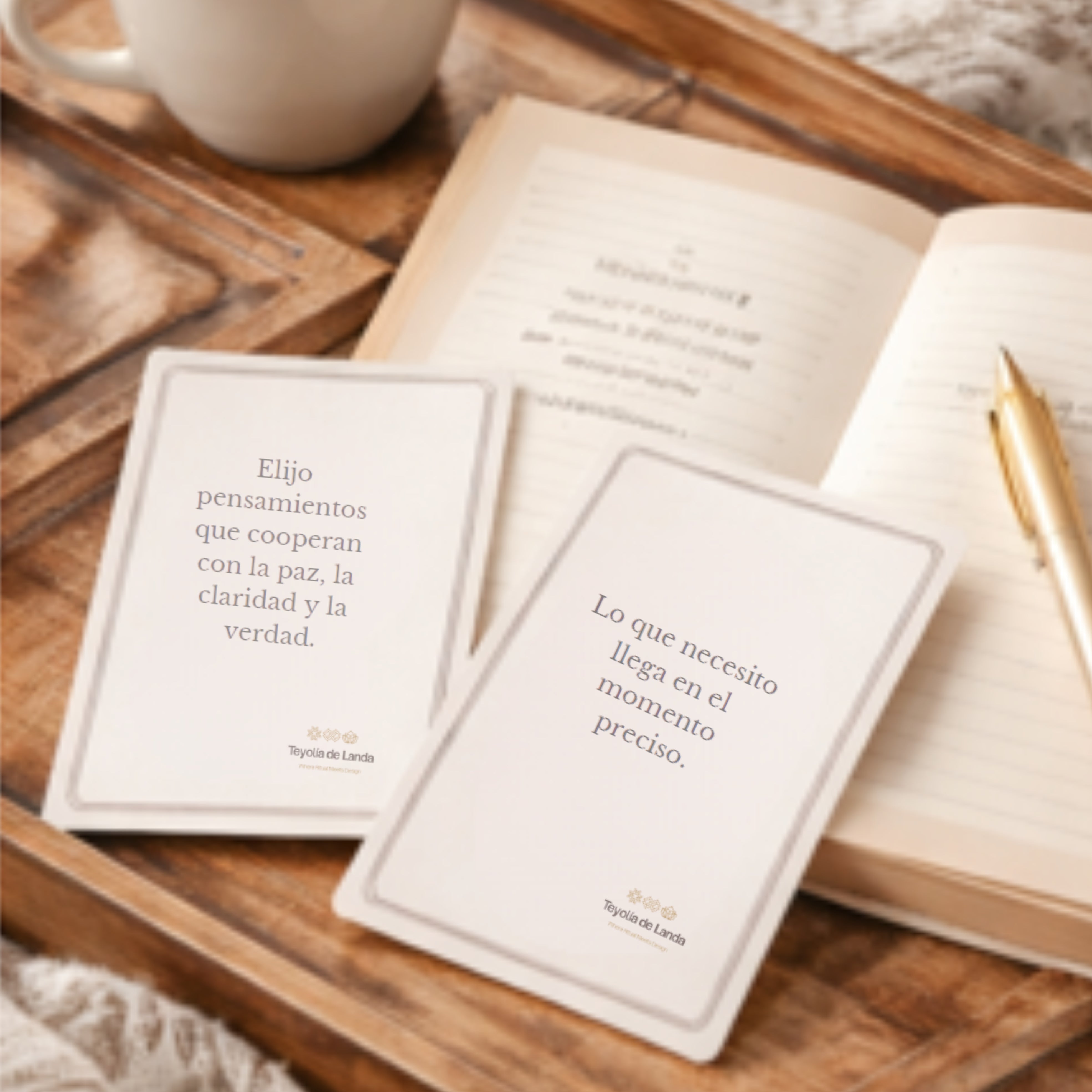 Two cards with inspirational quotes on a wooden tray with an open book and pen.
